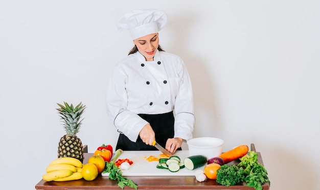 Eine Frau Küchenchef Schneiden von frischem Gemüse Konzept eines weiblichen Küchenchefs, der frisches Gemüse zubereitet Portrait von weiblichen Küchenchefs, der Gemüse schneidet Weiblicher Küchenchef, der Salat zubereitet