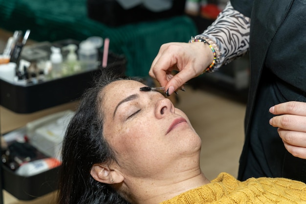 Eine Frau lässt sich in einem Salon die Augenbrauen machen