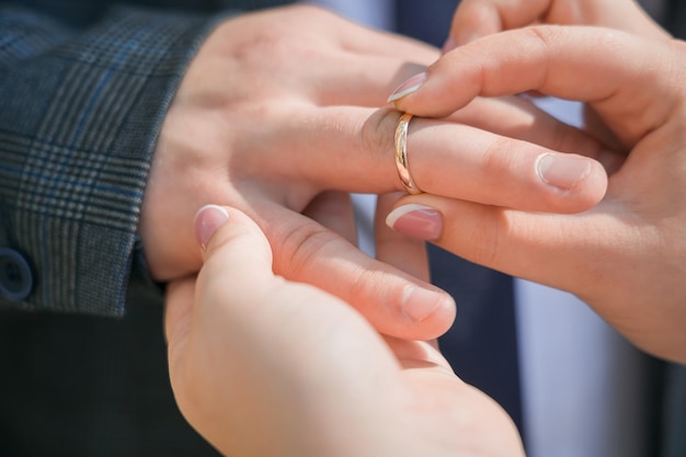 Foto eine frau legt einem mann einen ehering an den finger nahaufnahme