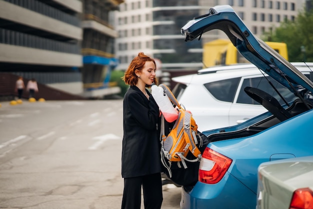 Eine Frau legt Sachen ins Auto