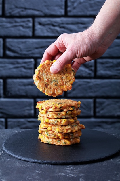 Eine Frau legte Maispfannkuchen auf einen Stapel Pfannkuchen