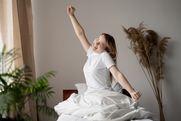 Eine Frau liegt nach einer erholsamen Nacht im Bett. Tolles Erwachen und der Beginn eines neuen Tages. Nachts ausruhen.