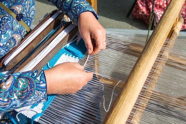 Eine Frau macht Stoff auf einem Handwebstuhl Der Stoff wird von Hand gefertigt