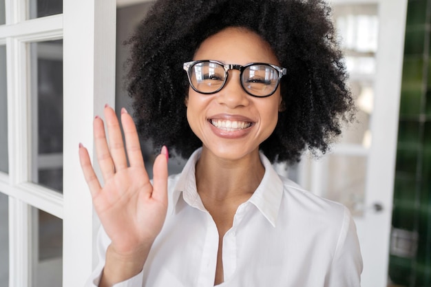 Eine Frau mit Brille lächelt Videokommunikations-Chat arbeitet Online-Kommunikation, der Bildschirm schaut in die Kamera