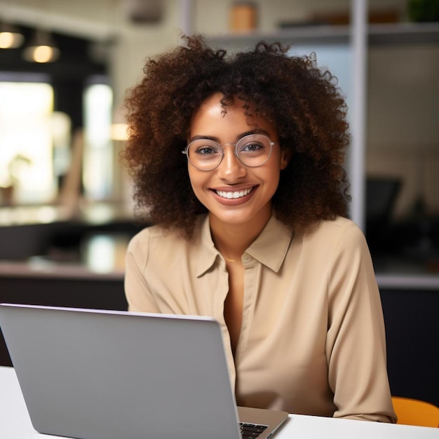 eine Frau mit Brille sitzt an einem Tisch mit einem Laptop