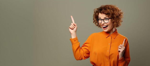 eine Frau mit Brille und einem orangefarbenen Hemd zeigt auf etwas