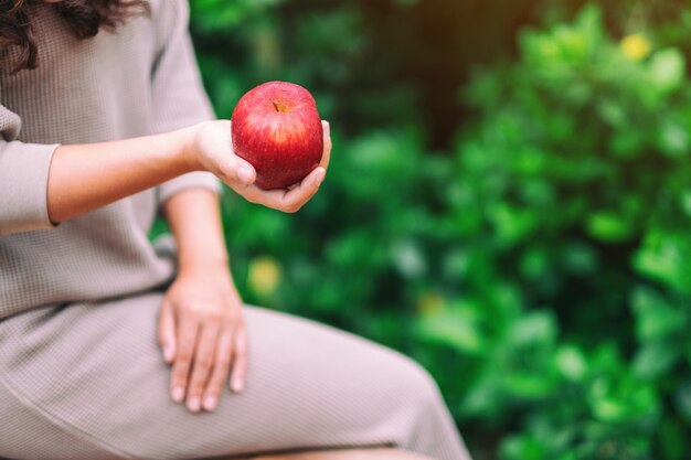 Eine Frau mit einem frischen roten Apfel in der Hand