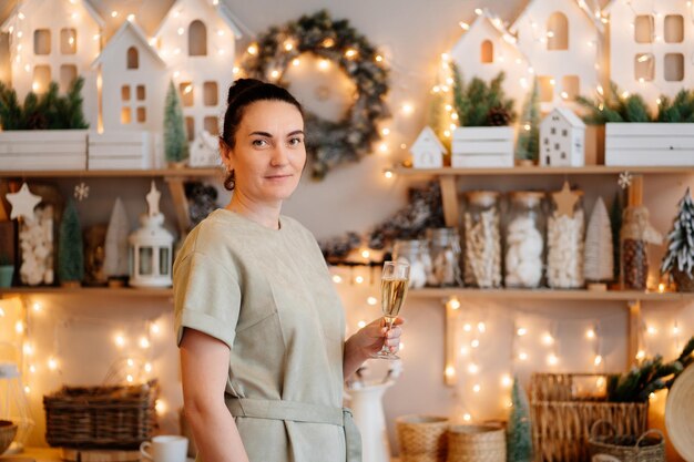 Eine Frau mit einem Glas in der dekorierten Silvesterküche