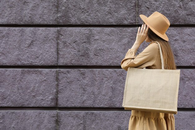 Foto eine frau mit einem hut und einer tasche auf der schulter