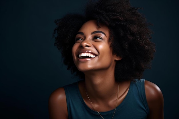 eine Frau mit einem natürlichen Afro lächelt vor einem schwarzen Hintergrund