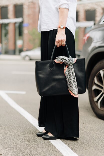 Eine Frau mit einer Tasche auf dem Hintergrund der Stadt