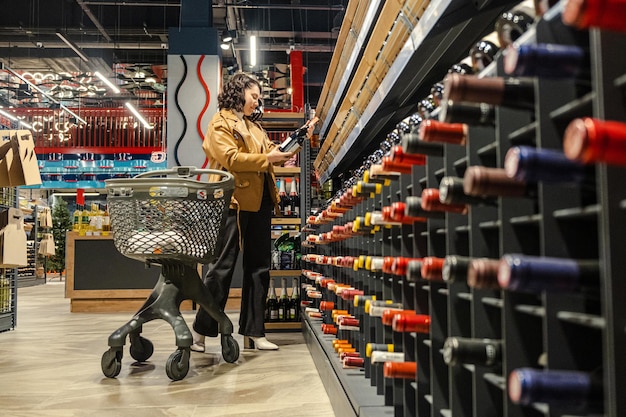 Foto eine frau mit einkaufswagen kauft in einem supermarkt ein