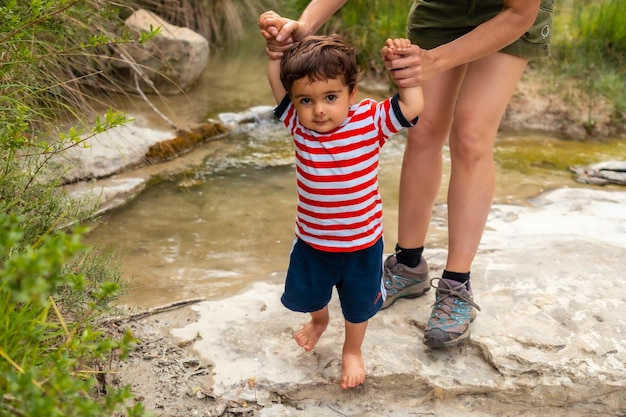 Eine Frau mit ihrem Sohn in einem Fluss im Sommer in den Sabinanigo-Pyrenäen