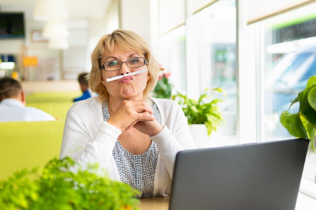 Eine Frau mit Laptop arbeitet in einem Café im Büro