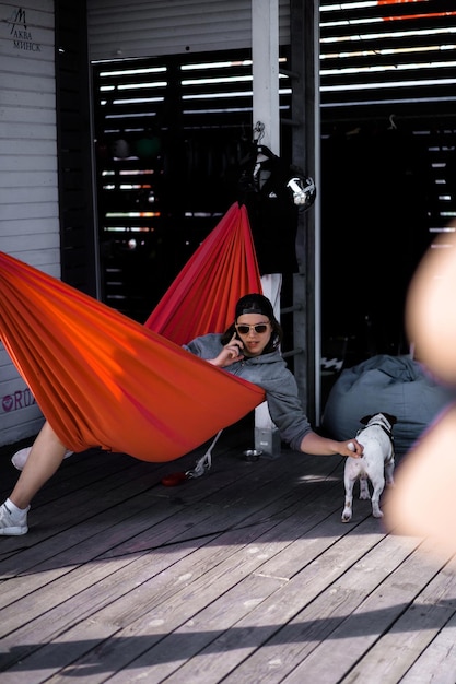 Eine Frau mit Sonnenbrille liegt in einer roten Hängematte