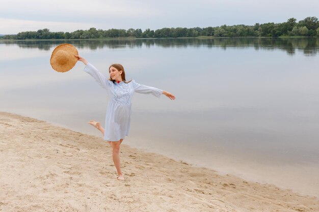 Eine Frau mit Strohhut am Strand in den Sommerferien