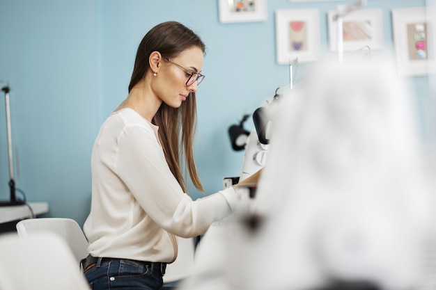 Eine Frau näht mit der elektrischen Nähmaschine Modeschneiderwerkstatt