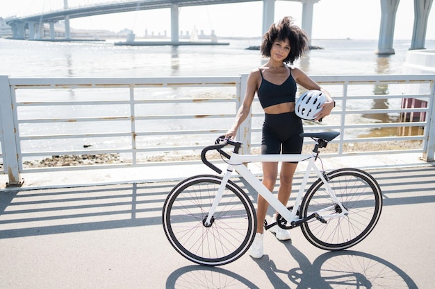 Eine Frau nutzt einen Fahrrad-Öko-Transport im Stadt-Fitness-Cardio-Training hält einen Helm