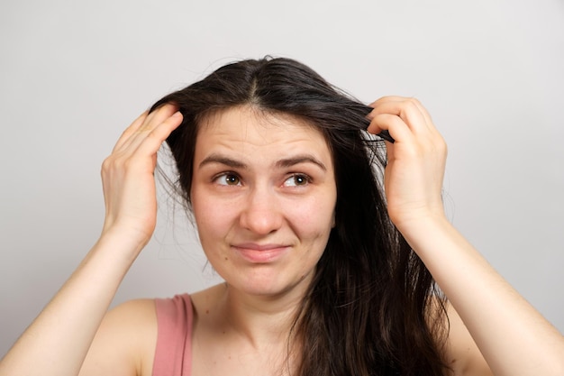 Eine Frau ohne Make-up mit schmutzigem, fettigem Haar