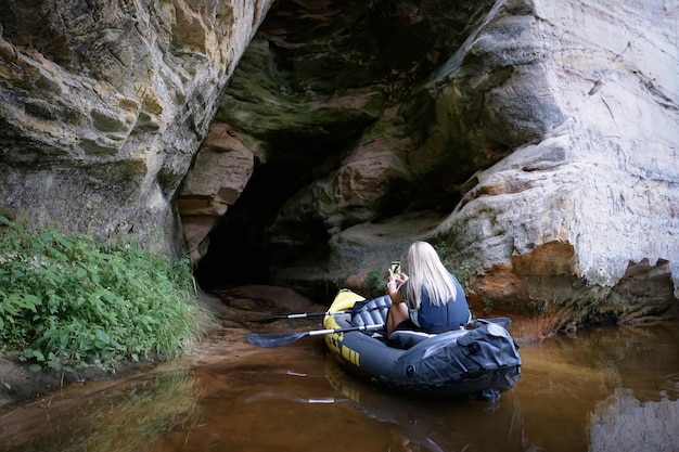 Eine Frau paddelt in einem Kajak in einer Höhle.