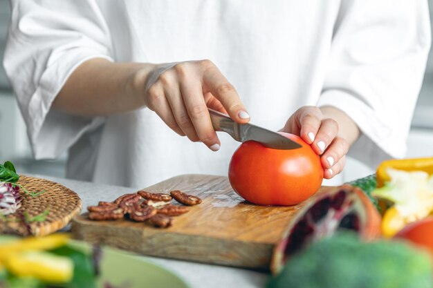 Eine Frau schneidet Gemüse für eine Salatnahaufnahme