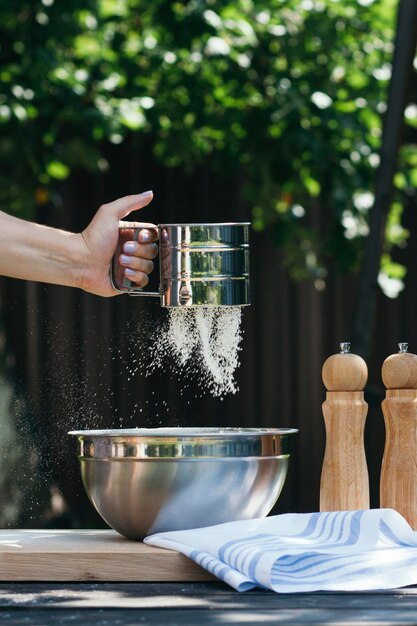 Foto eine frau siebt mehl für das backen