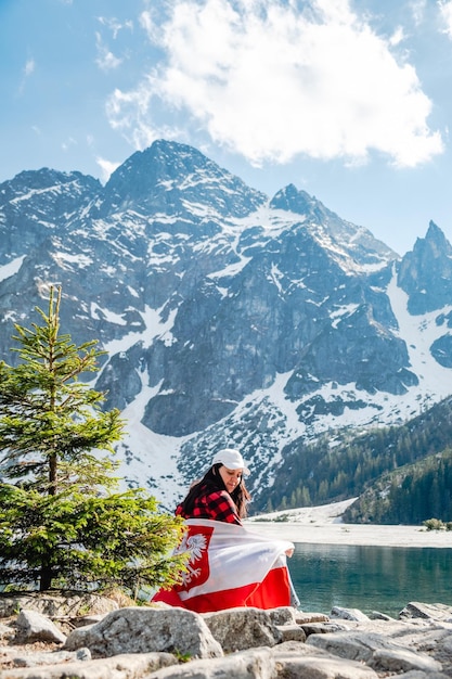 Eine Frau sitzt am Ufer eines Sees Morskie Oko Tatra