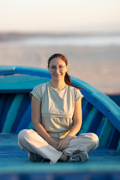 Eine Frau sitzt auf den blauen Brettern am Strandhafen