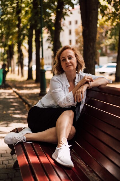 Eine Frau sitzt auf einer Parkbank