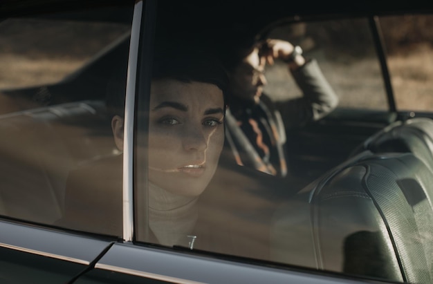 Eine Frau sitzt in einem Auto und schaut aus dem Fenster.