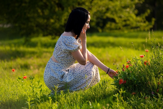 Eine Frau sitzt in einer Blumenwiese.