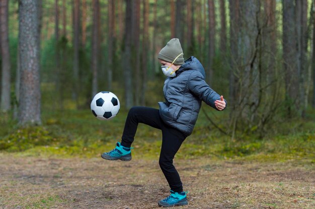 Foto eine frau spielt fußball im wald in voller länge