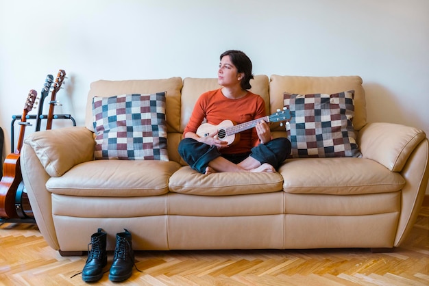 Foto eine frau spielt zu hause ukulele