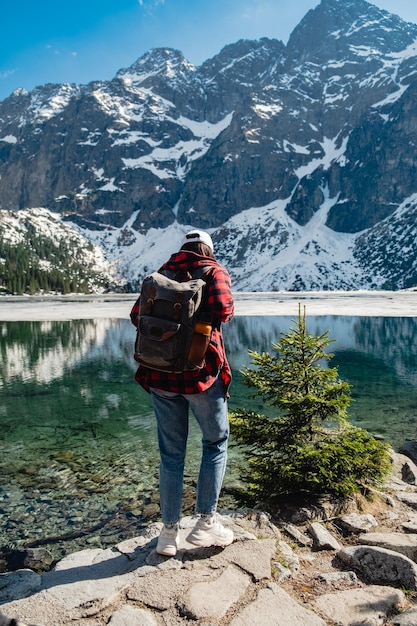 Eine Frau steht am Ufer eines Sees Morskie Oko Tatra