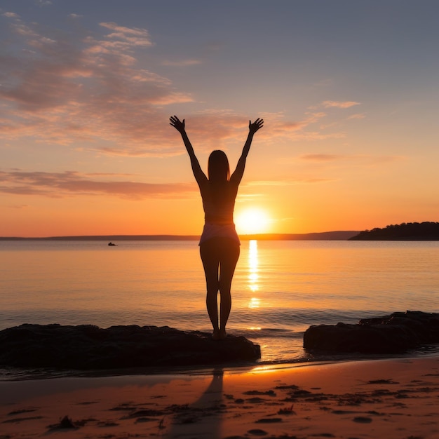 Eine Frau steht bei Sonnenaufgang am Strand