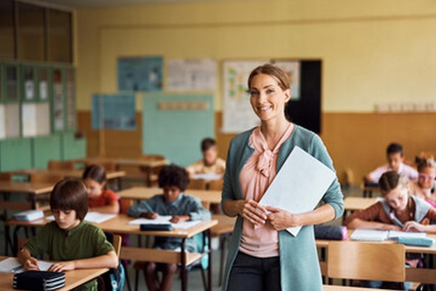 eine Frau steht in einem Klassenzimmer mit einem Buch in der Hand