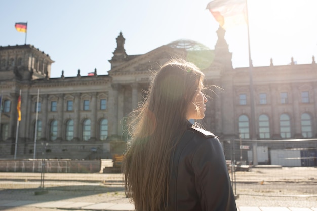 Eine Frau steht vor einem Gebäude, auf dem das Wort Reichstag steht.