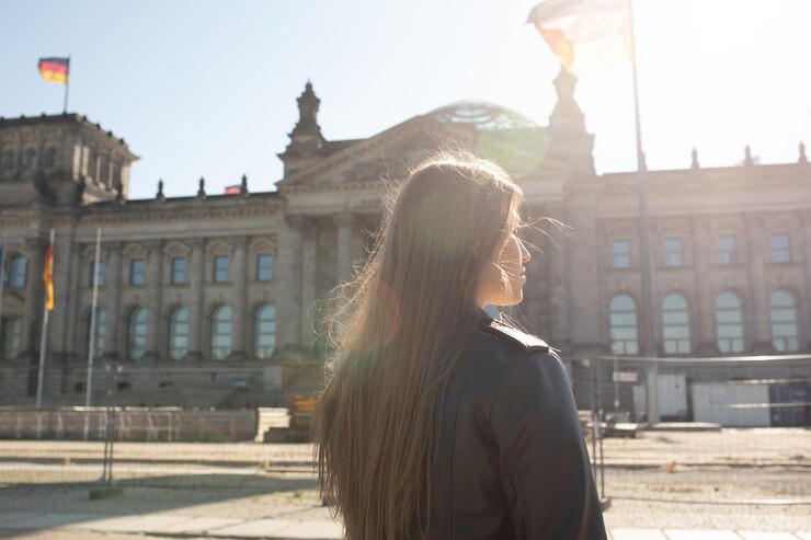 Foto eine frau steht vor einem gebäude, auf dem das wort reichstag steht.