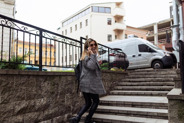 Eine Frau steigt die Treppe hinauf, spricht auf ein Handy und dreht sich um