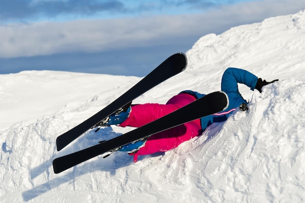 Eine Frau stürzte auf Skiern von einem Berg im Schnee. Hochriskante Aktivität oder Extremsport-Versicherungskonzept