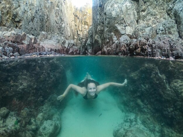 Eine Frau taucht in einen natürlichen Pool namens Lasca da Velha Fernando de Noronha