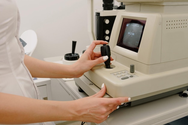 Eine Frau überprüft mit einem Mikroskop die Temperatur eines Patienten.