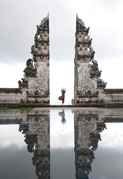 Foto eine frau übt yoga am eingang mit einer reflexion im pool