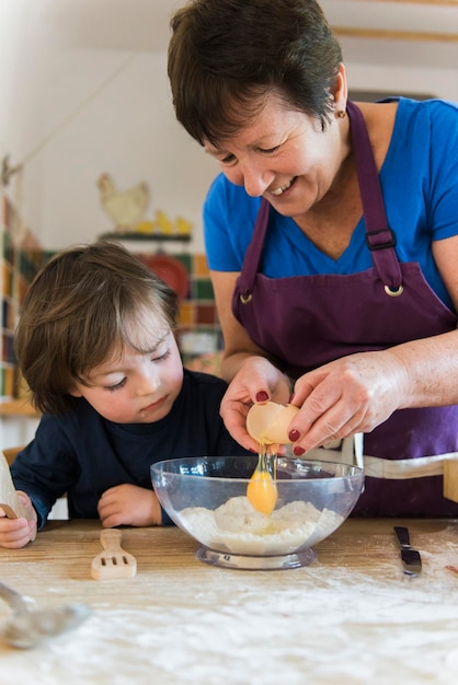 Eine Frau und ein Kind kochen an einem Küchentisch und backen Feenkuchen