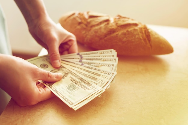 Eine Frau zählt Geld auf dem Hintergrund des Brotfinanzkonzepts für das Familienbudget