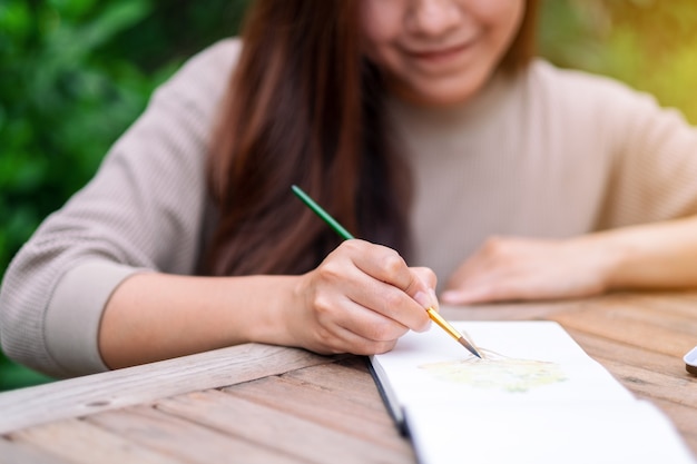 Eine Frau zeichnet und malt mit Aquarell