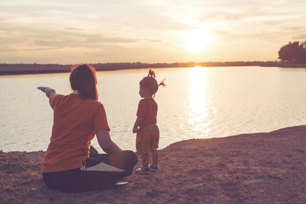 Foto eine frau zeigt der tochter den see mit gebärden