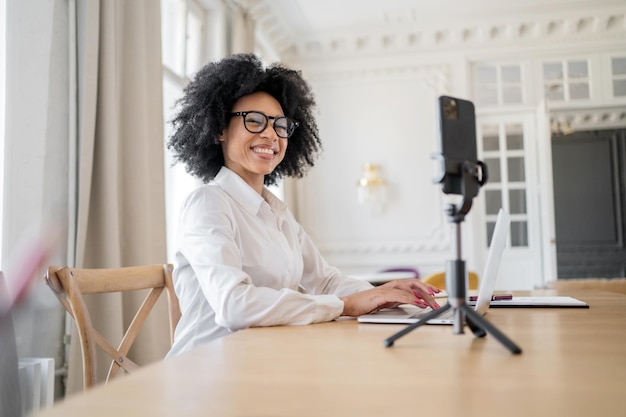 Eine Freiberuflerin mit Brille im Büro arbeitet mit einem Laptop an einem Startup-Projekt