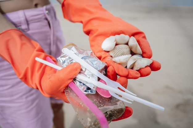 Eine freiwillige Ökologin reinigt den Strand an der Meeresküste von Plastik und anderen Abfällen