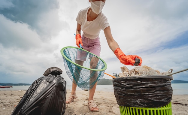 Eine freiwillige Ökologin reinigt den Strand an der Meeresküste von Plastik und anderen Abfällen